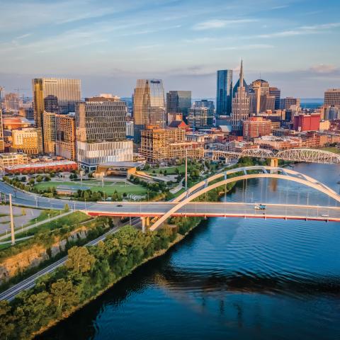 The Shelby Street Bridge, crossing the Cumberland River, and the downtown skyline at sunrise in Nashville, Tennessee.
